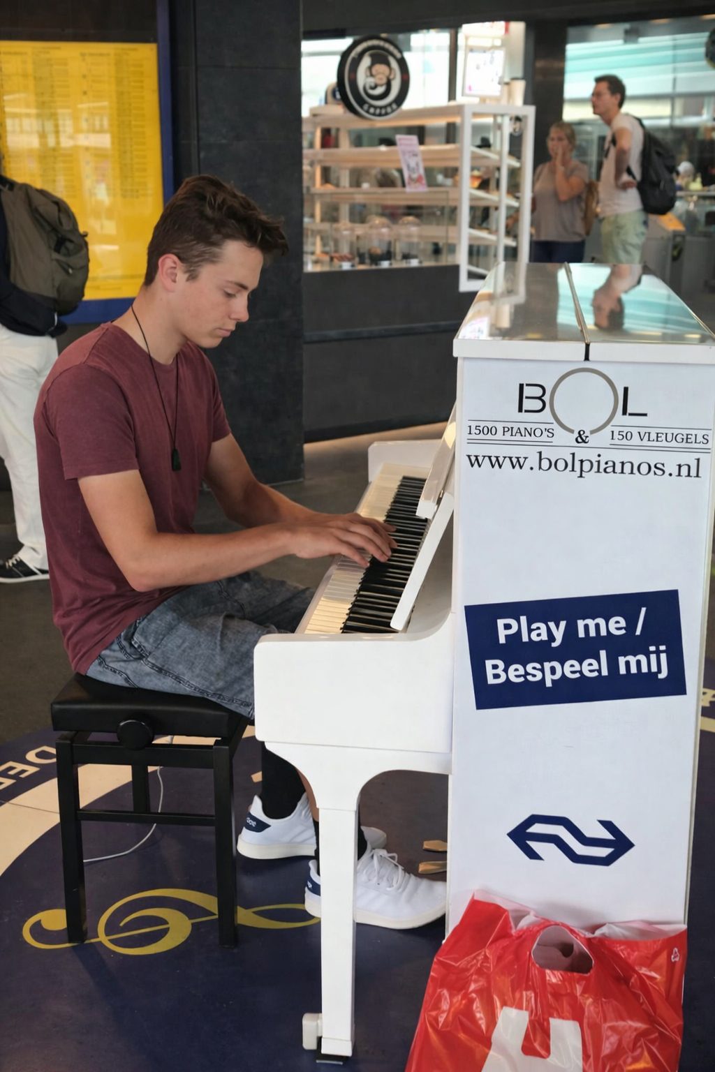 A student playing a public piano while on holiday